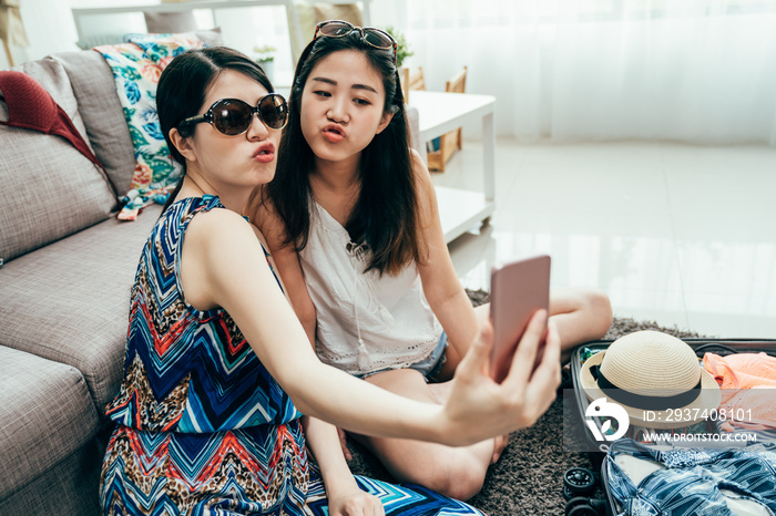 Positive friends portrait of two happy sister girls making selfie on smart phone pout funny faces gr