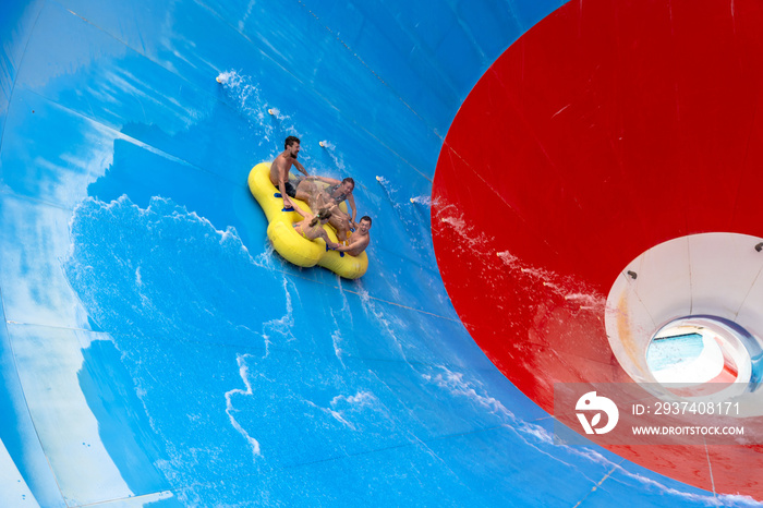 Friends having fun sliding in a big water slide