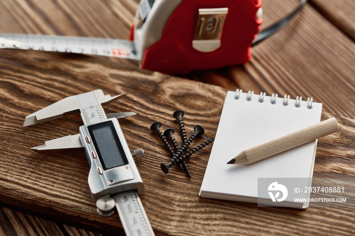 Measuring tape, caliper and notebook, macro view