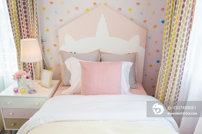 一间漂亮的女儿卧室，有一个粉红色的枕头和一张有甜美墙壁的粉红色床。