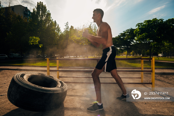 无衬衫男子在crossfit健身房翻重轮胎