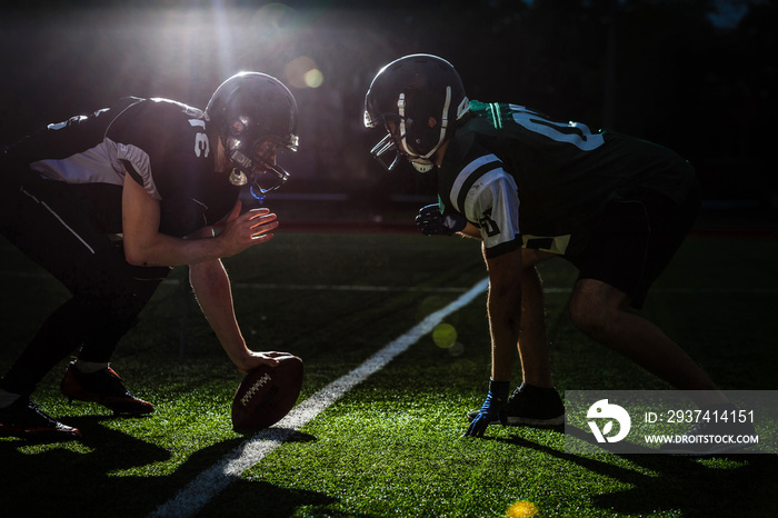 American football players are ready to start a match on modern field at night