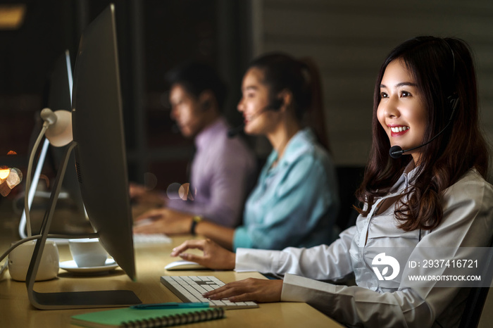 Asian Female customer care service with business man smiling and working hard late in night shift at