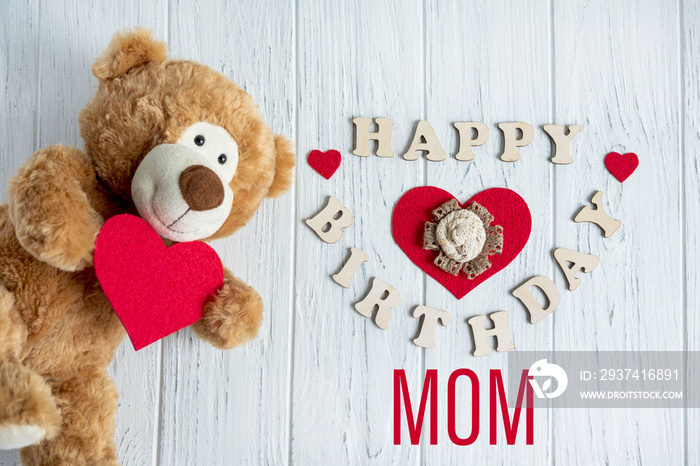 妈妈生日快乐。妈妈生日贺卡设计，带一只泰迪熊和一颗心。平面布局