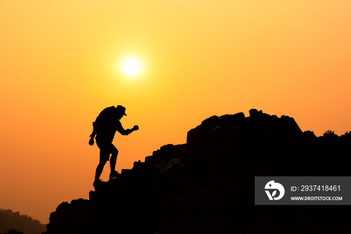 Silhouette of a young man who has successfully climbed a mountain, the concept of a mountain climbin