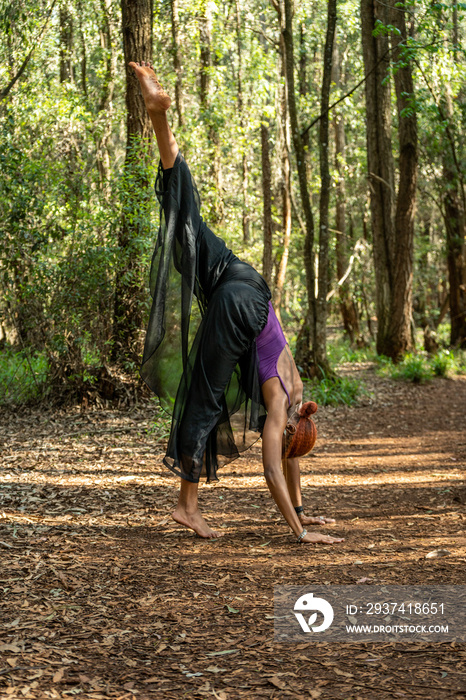 woman doing deep yoga stretch in the forest