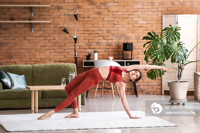 Young woman practicing yoga at home