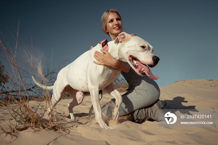 带着白色阿根廷多戈犬的女人