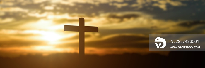 日落背景下的天主教十字架剪影。全景图