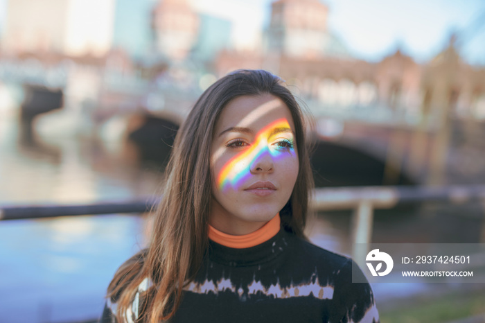 young woman with rainbow in face under the eyes on sunset millenials hipsters colorated in Berlin by