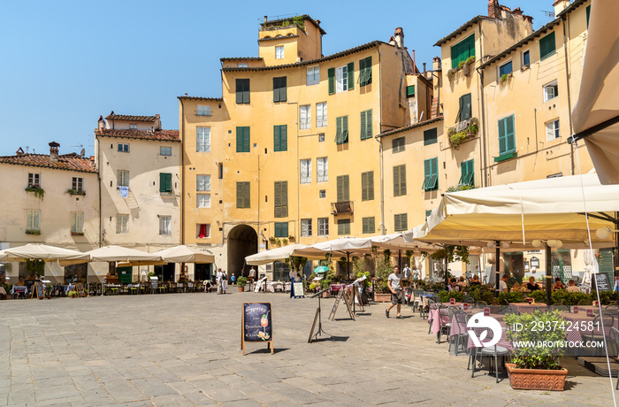 Amphitheater square with restaurants, bars and tourists in old town Lucca, Tuscany, Italy