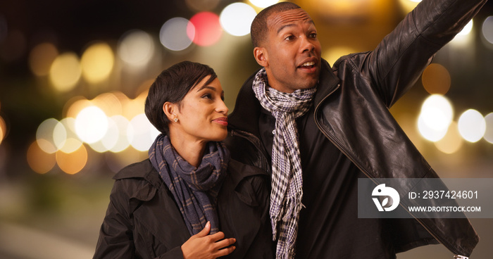 A black couple calls and finds their taxi on a busy street. An African American man and woman see wh