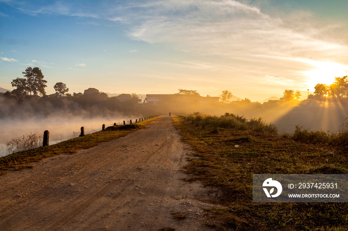 dried dirt road and lake at morning sunrise