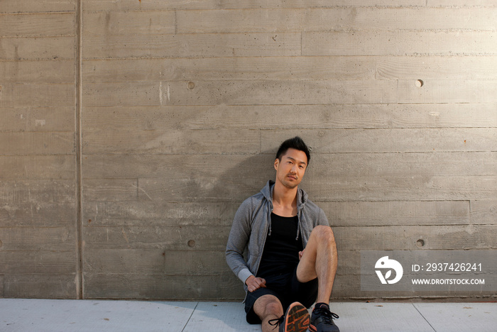 Runner sitting on city street