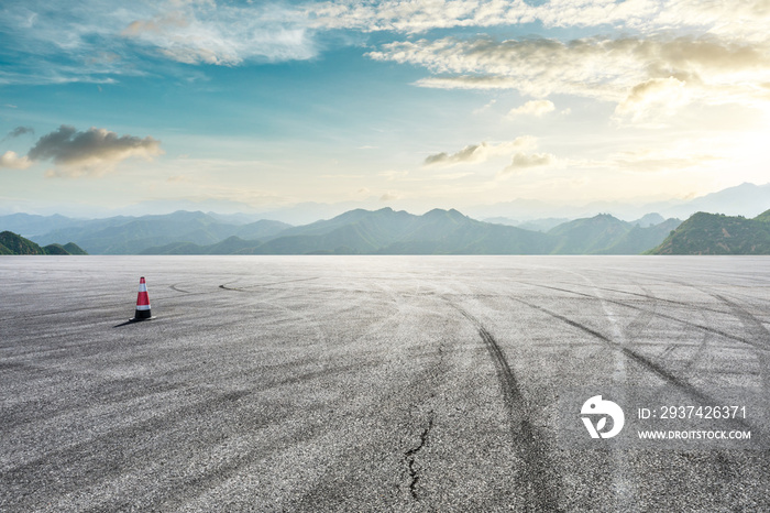 Asphalt race track ground and mountain with sunset clouds