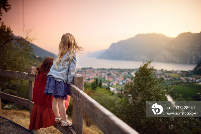 Two little sisters enjoying scenic aerial view of Riva del Garda town, located on a shore of Garda l