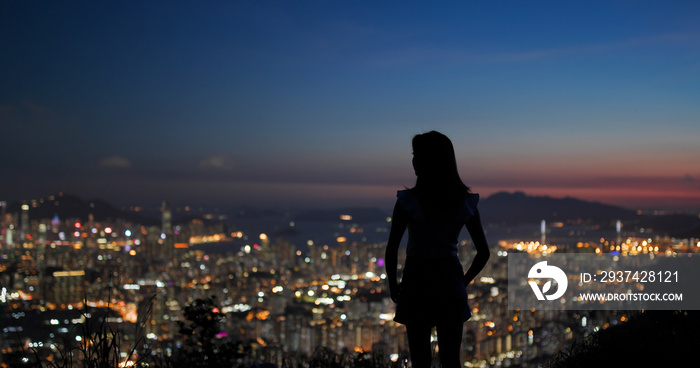 日落下女人欣赏城市美景