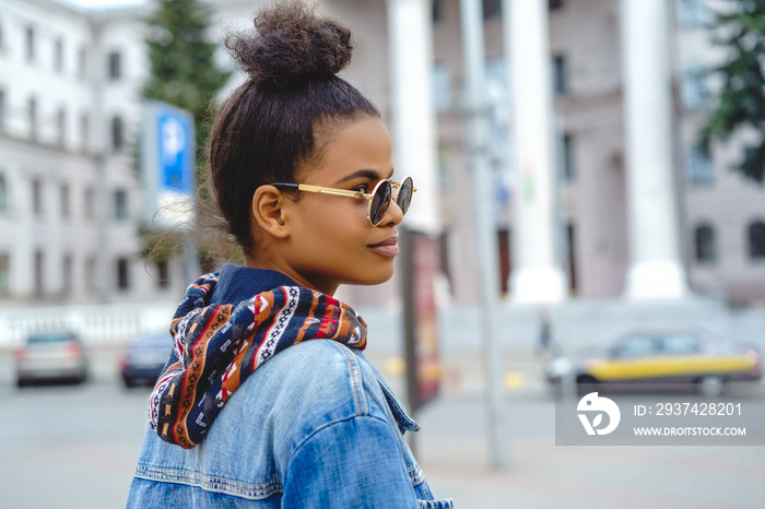 时尚的非裔美国女孩在城市街道上戴着墨镜
