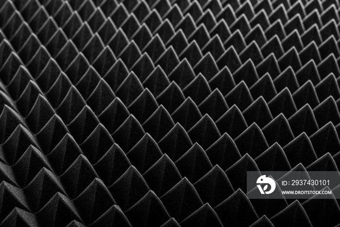 Abstract background in the form of pyramids and dragon scales. Acoustic black foam rubber.