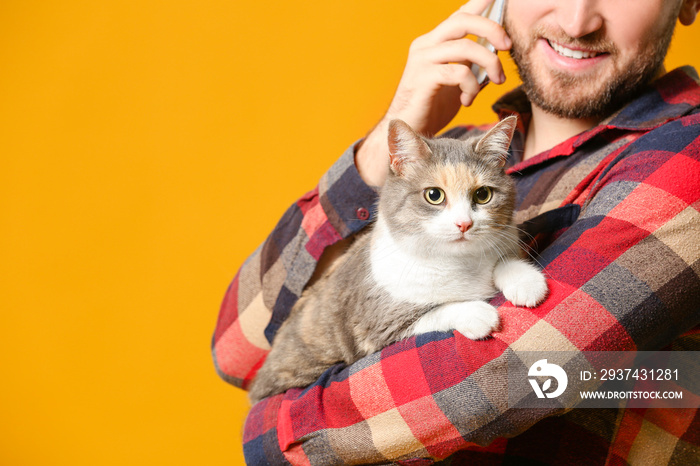 男人带着可爱的猫在彩色背景下打电话