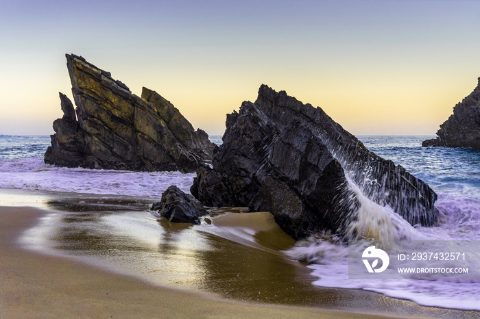 Rocky beach at sunrise, Adraga, Portugal. Travel and business background