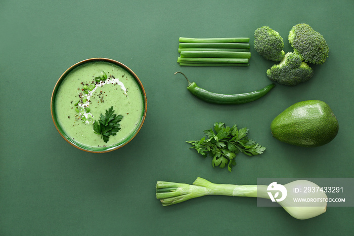 Bowl of tasty cream soup and ingredients on color background