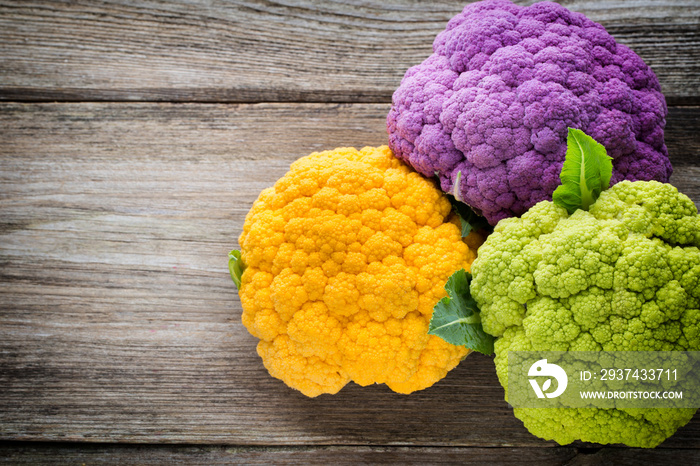 Rainbow of eco cauliflower on the wooden table.