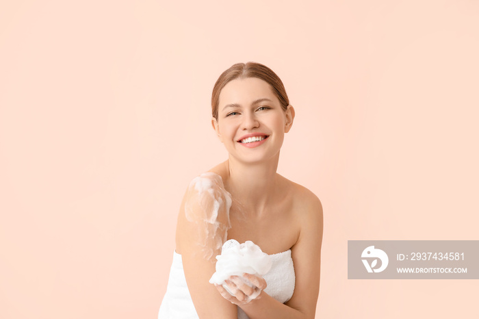 Beautiful young woman taking shower on color background