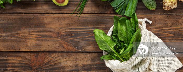 Shopping bag with green vegetable on wooden background top view. Healthy food clean eating. Copy spa