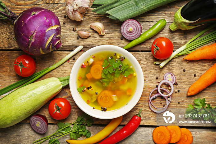Soup and fresh vegetables on wooden background