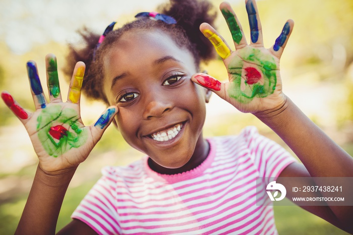 Little girl showing her painted hands to the camera