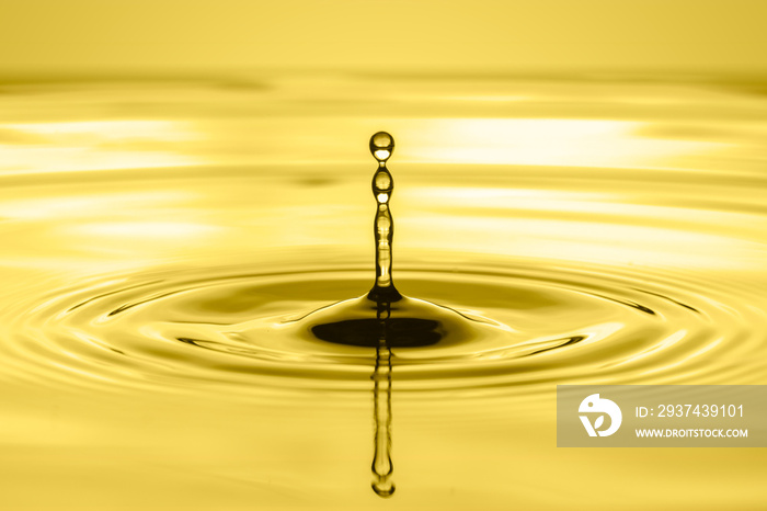一滴植物油或机油水，在金色背景上泛起涟漪。