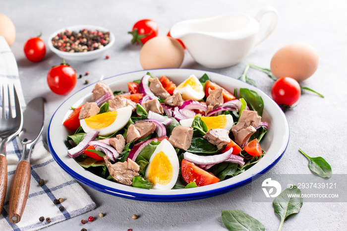 Salad from cod liver, eggs and vegetables on a plate. Nutritious, useful.