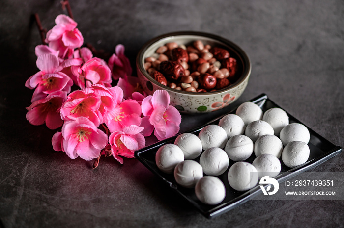 Tangyuan, peanuts, red dates and flowers on the table