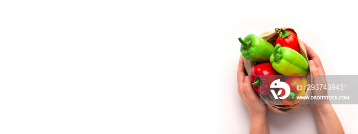 Farmer hands holding colored paprika in eco friendly paper bag