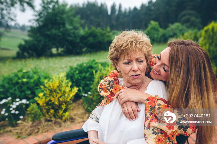 Senior dissatisfied woman in a wheelchair with her daughter