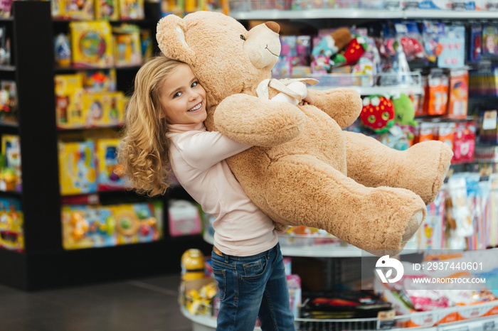微笑的小女孩抱着大泰迪熊