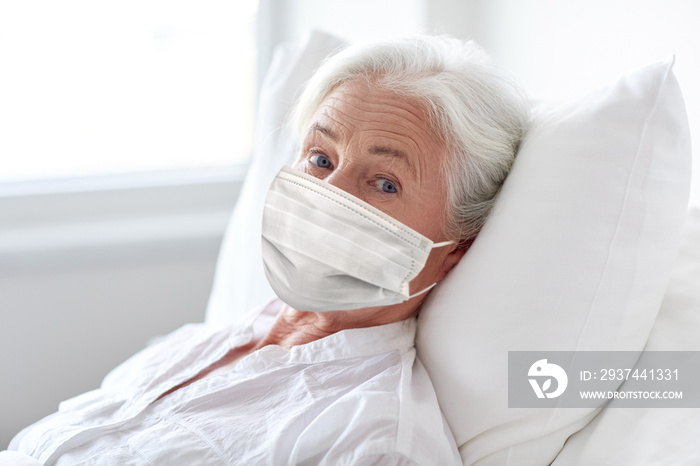 medicine, health safety and pandemic concept - senior woman patient lying in bed wearing face protec