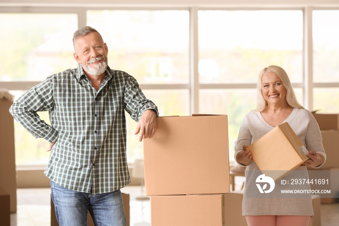 Mature couple with moving boxes at new home