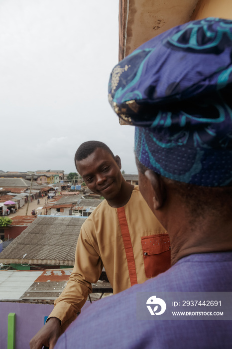 Son smiling at father outside their balcony