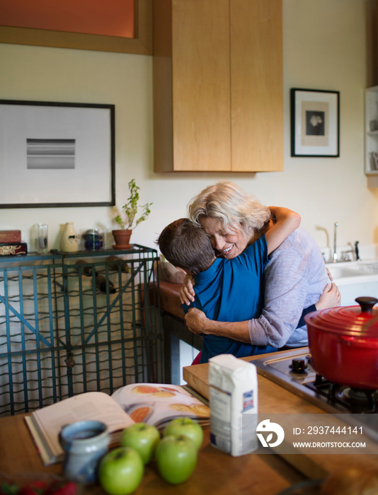 Grandma hugging her grandson in kitchen