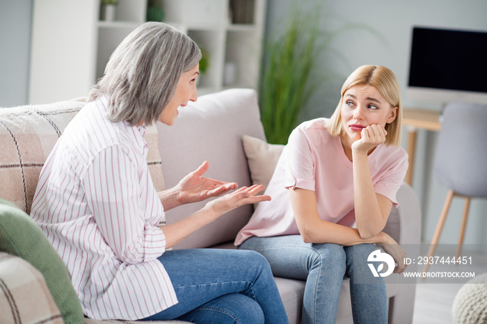 Photo of unhappy bored young woman and old lady talk sit sofa wear casual outfit indoors inside hous