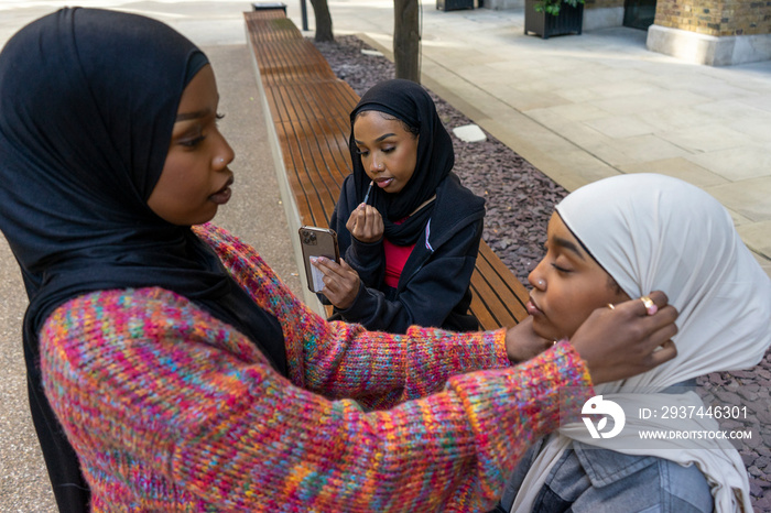 Young woman adjusting friends�hijab