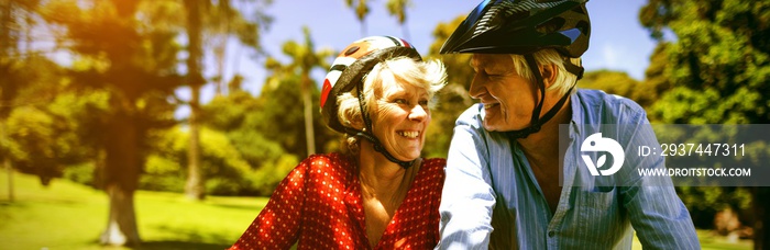 Happy couple riding a bicycle in park