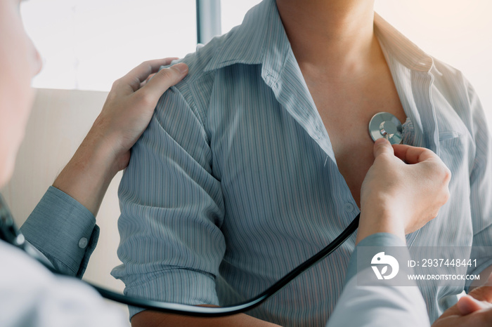 Asian doctor is using a stethoscope listen to the heartbeat of the elderly patient.