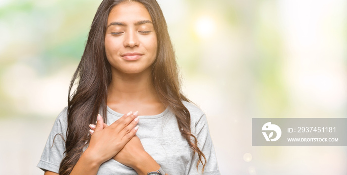 Young beautiful arab woman over isolated background smiling with hands on chest with closed eyes and