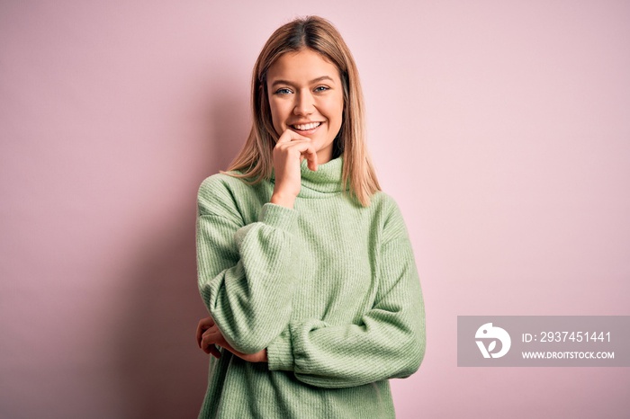 Young beautiful blonde woman wearing winter wool sweater over pink isolated background looking confi