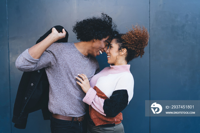 Happy ethnic couple hugging on street