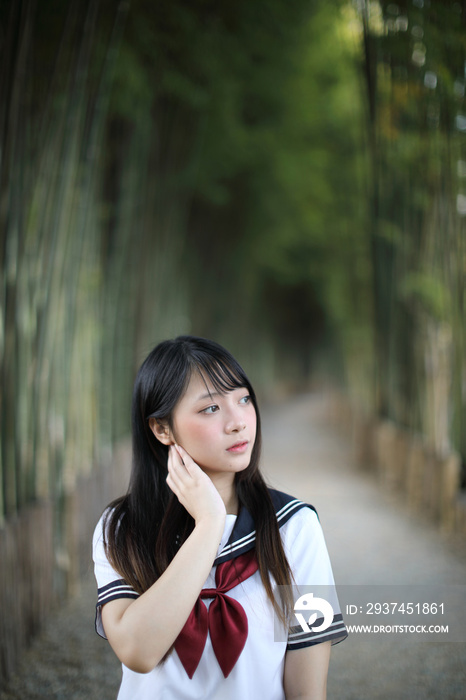 美丽的亚裔日本高中女生制服的肖像，以竹林为背景
