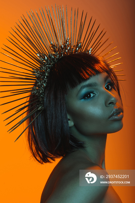 portrait of stylish african american woman posing in headpiece with needles